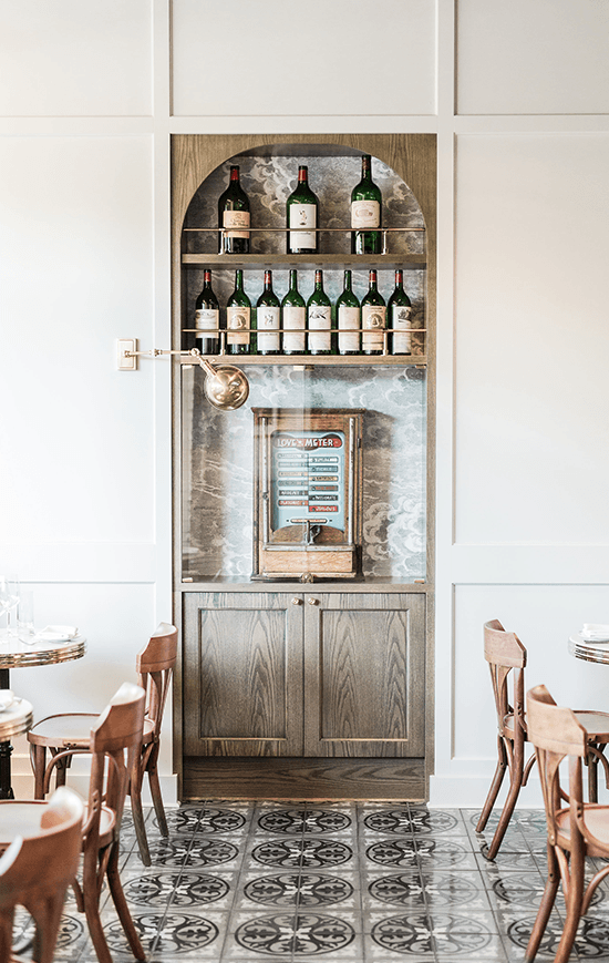 A cabinet that has shelves is filled with liquor